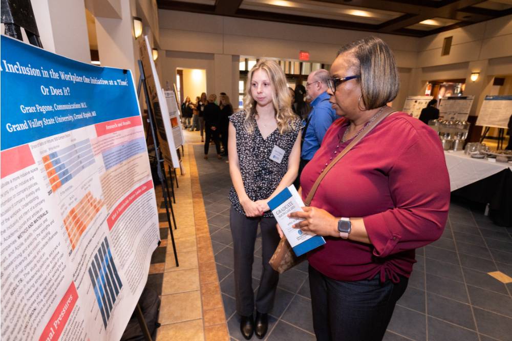 Grace (left) presenting to a guest at the 2023 Graduate Showcase.